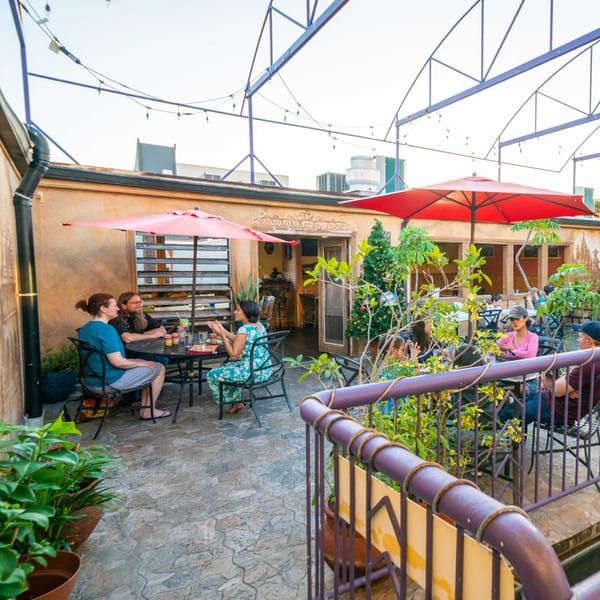 Patrons enjoying Indian food and drinks on the outdoor patio of Himalayan Kitchen Hawaii.