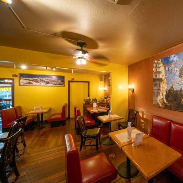 Interior of Himalayan Kitchen Hawaii, with red booths, wooden tables, and Himalayan-themed decor.